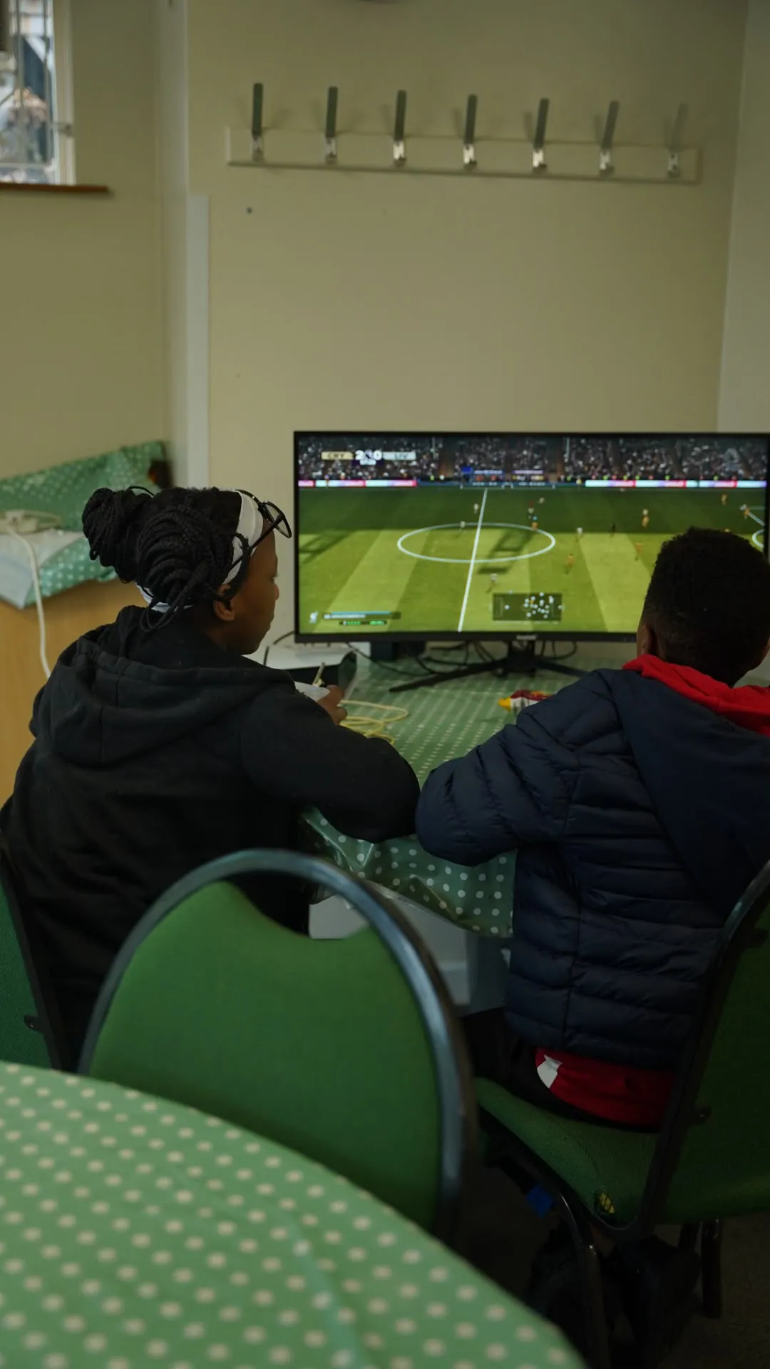 Two young people playing a football video game together