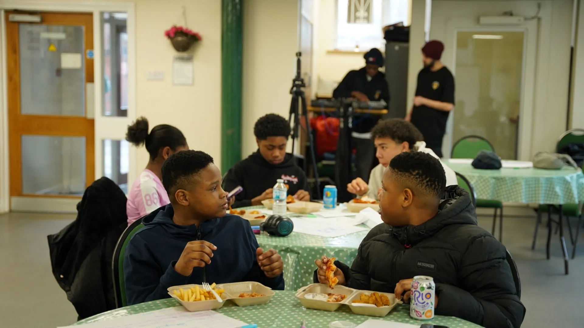 Young people sharing food and talking around a table