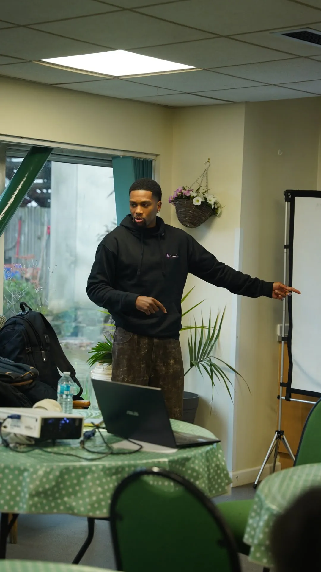 A Care Cove staff member pointing to a flip chart while leading a session